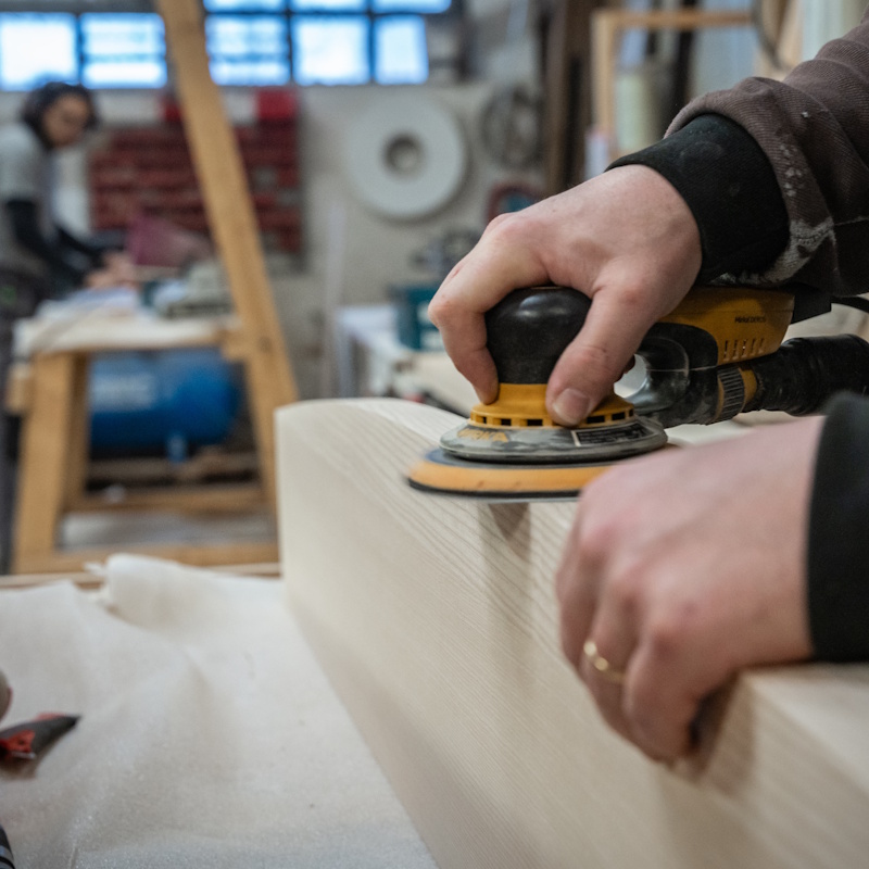 Ponçage d'une planche en bois en atelier