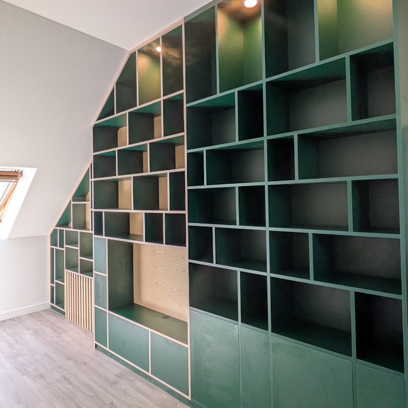 Bibliothèque murale verte sous plafond mansardé
