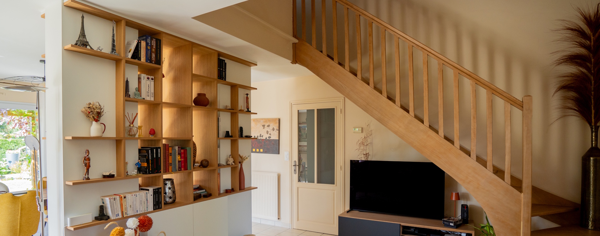 Salon moderne avec escalier en bois et bibliothèque