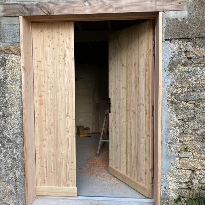 Porte en bois neuve dans mur en pierre
